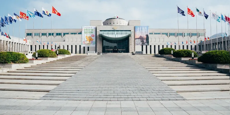 Large building with multiple flags and wide steps.